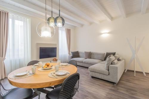 un soggiorno con tavolo e divano di Modern & Stylish Apartment in Como City by Rent All Como a Como