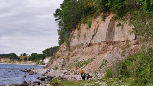 a group of people standing on the rocks near the water at Mare Balticum Urlaub auf Rügen in Sagard
