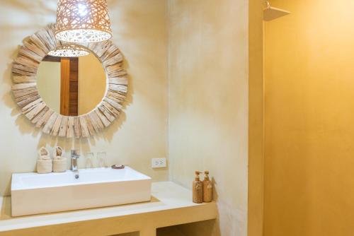 a bathroom with a white sink and a mirror at Riviera Beach Hotel in Bophut