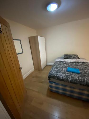 a bedroom with a bed with a blue object on it at BIG ROOM rusholme WITH TV AND PRIVATE BATHROOM-parking&wifi in Manchester