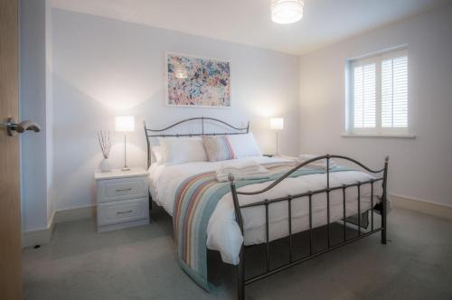 1 dormitorio con 1 cama, 2 lámparas y ventana en Minarvon - 2 Bedroom Apartment - Saundersfoot, en Saundersfoot
