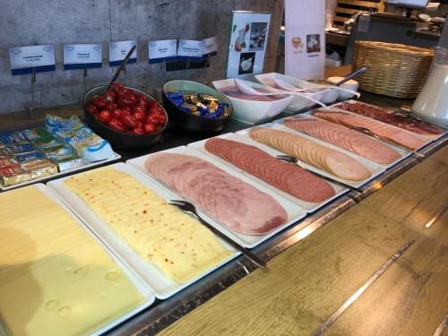 a buffet with meats and cheese and other foods at ibis budget Muenchen Putzbrunn in Putzbrunn