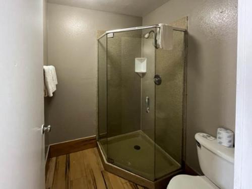 a glass shower in a bathroom with a toilet at Motel 6 Riviera Beach FL in Riviera Beach