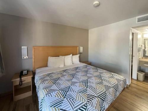 een slaapkamer met een bed met een blauw en wit dekbed bij Motel 6 Riviera Beach FL in Riviera Beach