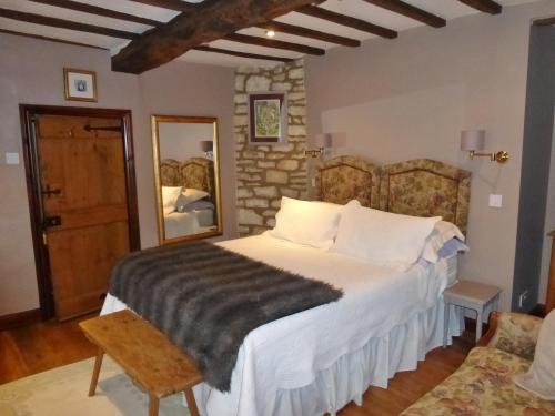 a bedroom with a bed and a stone wall at Badgers Hall in Chipping Campden