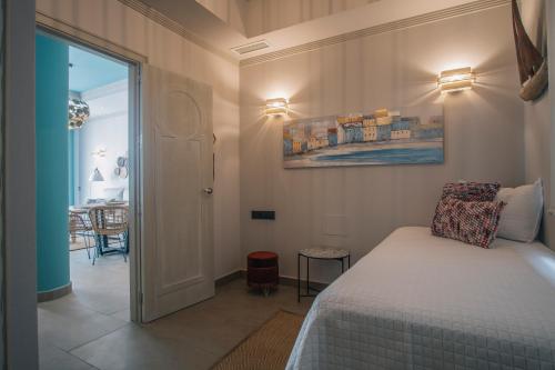 a bedroom with a bed and a dining room at Apartamentos Turísticos La Baílla in Rota