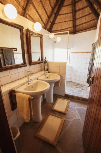 a bathroom with two sinks and a mirror at Huab Lodge & Bush Spa in Kamanjab