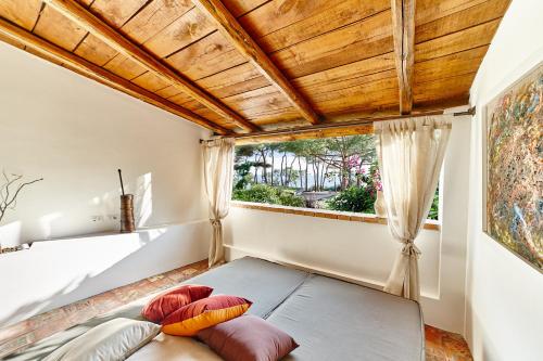 Schlafzimmer mit einem Bett und einem Fenster in der Unterkunft Praia Art Resort - Small Luxury Hotels of the world in Le Castella