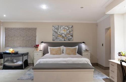 Rueby’s Guesthouse في دولستروم: غرفة نوم بسرير كبير ولوحة على الحائط