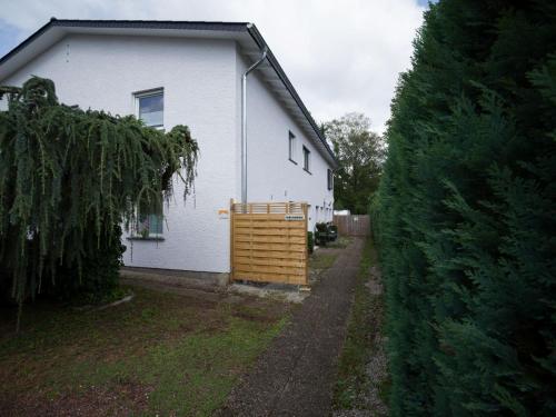 Casa blanca con puerta de madera en un patio en Ferienwohnung auf dem Kore, en Kirkel