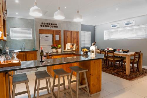 a kitchen with a large island with bar stools at Rueby’s Guesthouse in Dullstroom
