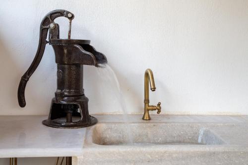 a faucet with water pouring into a sink at Eleni Zirganou Studios & Apartments in Milína