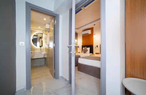 a bathroom with a bed and a sink and a mirror at HOTEL DESTİLL in Antalya