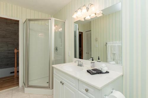 a white bathroom with a sink and a shower at Star View Cabin - Powder Horn Mountain in Powderhorn Mountain