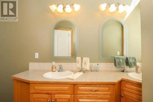 uma casa de banho com dois lavatórios e dois espelhos em Lakeshore Guest House - sleeps 18 em Sylvan Lake