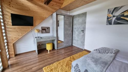 a bedroom with a bed and a tv in a room at RIVER REST - ADULTS ONLY in Świeradów-Zdrój