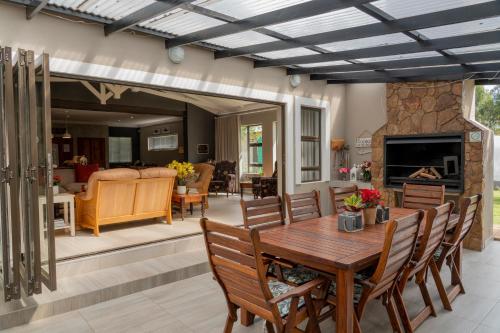 a patio with a table and chairs and a fireplace at Rueby’s Guesthouse in Dullstroom