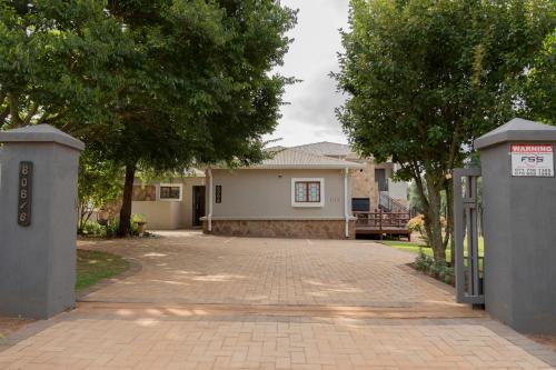 a house with a brick driveway in front of a house at Rueby’s Guesthouse in Dullstroom
