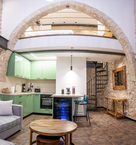 an open kitchen and living room with green cabinets at Palazzino Luxury Suites in Lofou