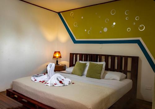 1 dormitorio con 1 cama con techo azul y verde en Eco Stay Hostel en San José