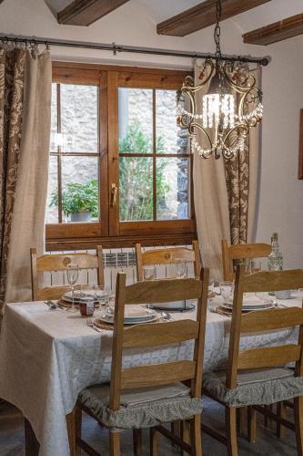 a dining room with a table and chairs and a chandelier at Apartamentos Casa Pichuana in Benasque