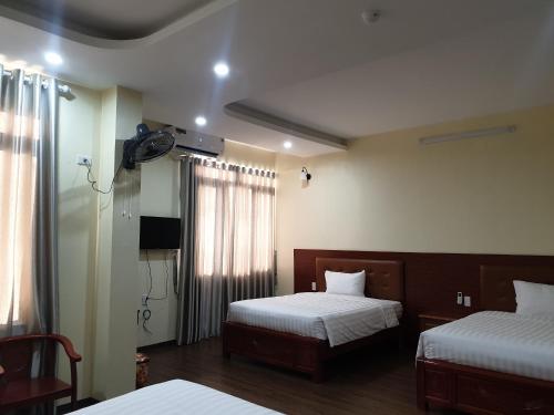 una camera d'albergo con due letti e una televisione di THANH XUÂN HOTEL a Cao Bằng