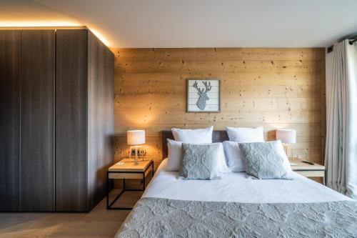 a bedroom with a bed and a wooden wall at Apartment Cortirion Megeve - by EMERALD STAY in Megève