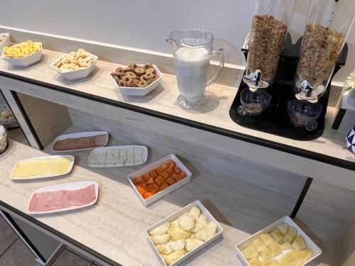 a counter with bowls of food and a blender at Europa Hotel Brasília by Bsb Inn in Taguatinga