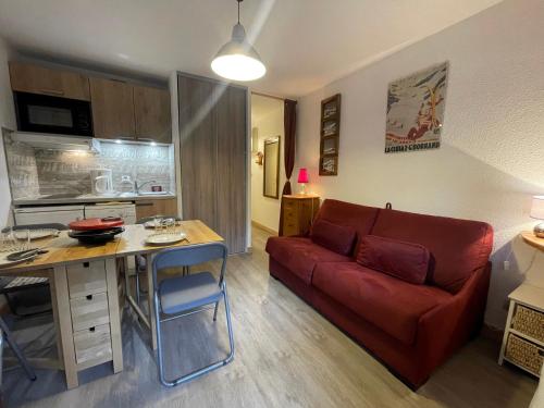 un salon avec un canapé rouge et une table dans l'établissement Cotagnes 1 - Appartement proche pistes, à La Clusaz