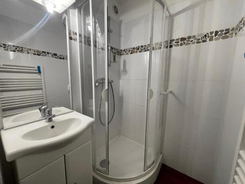 une salle de bain blanche avec un lavabo et une douche dans l'établissement Cotagnes 1 - Appartement proche pistes, à La Clusaz