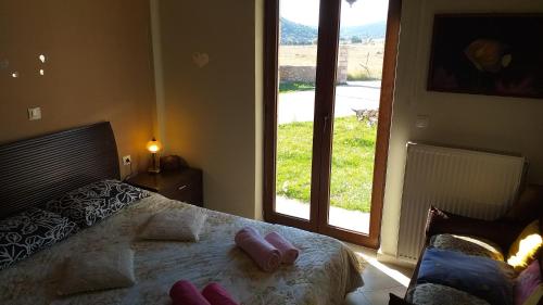 a bedroom with a bed with two pink towels on it at Arachova Houses-Ευήλιον ΛΙΒΑΔΙ in Arachova