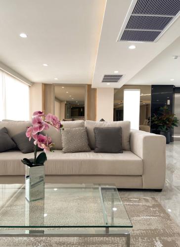 a living room with a couch and a glass table at Oriole Residence - Suvarnabhumi Airport in Ban Khlong Thewa