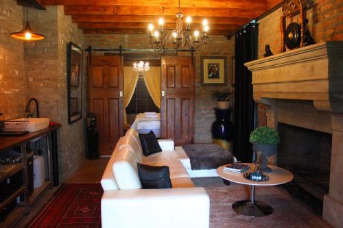 a living room with a couch and a fireplace at Furrows Lodge in Nieu-Bethesda
