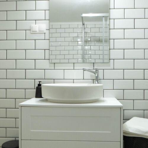 Baño blanco con lavabo y espejo en Fakapu Vendégház en Sárospatak