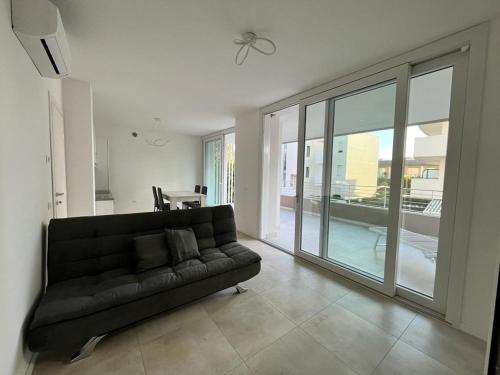 a black couch in a living room with a large window at Ulisse Palace in Lido di Jesolo