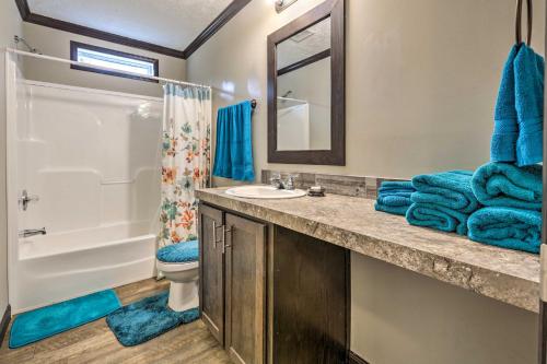 W łazience znajduje się umywalka, toaleta i lustro. w obiekcie Lovely Sadieville Retreat with Deck and Grill! w mieście Corinth