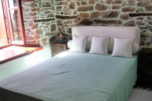 łóżko w pokoju z kamienną ścianą w obiekcie Wonderful 4 Bedroom Villa & separate guest house Villa Thalia w mieście Zagora
