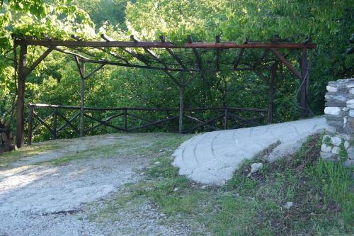 a wooden bridge over a dirt road next to trees at Wonderful 4 Bedroom Villa & separate guest house Villa Thalia in Zagora
