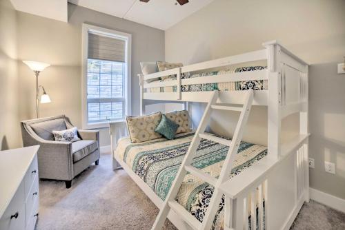 a bedroom with two bunk beds and a chair at Luxe Manistee Condo with Balcony and River Views! in Manistee