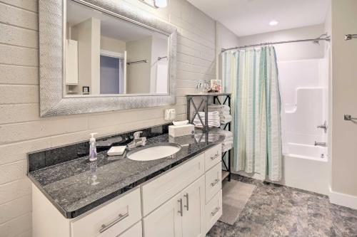a bathroom with a sink and a mirror and a shower at Luxe Manistee Condo with Balcony and River Views! in Manistee