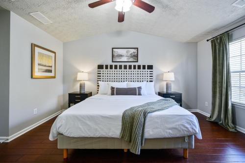 - une chambre avec un grand lit et un ventilateur de plafond dans l'établissement Stay In This Chic Townhome Near Olde Rope Mill, à Woodstock
