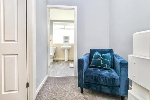 een blauwe stoel in een badkamer met een wastafel bij City Centre 3 Bed House for Large Groups and Contractors by Amazing Spaces Relocations Ltd in Liverpool