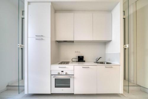 une cuisine avec des armoires blanches et un évier dans l'établissement REF 1490 - Cannes Le Suquet - Apartment for rent, à Cannes