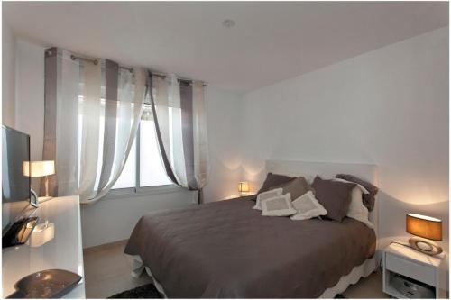une chambre avec un grand lit et une fenêtre dans l'établissement REF 912 - Cannes Center - Apartment for rent, à Cannes