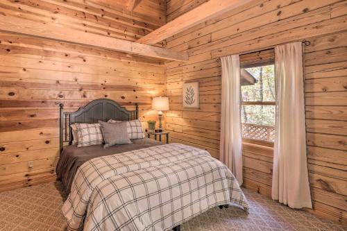 1 dormitorio con 1 cama en una cabaña de madera en Serenity Woods Cabin with Hot Tub and Fire Pit, en Mountain Home