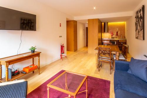 a living room with a blue couch and a table at Garça Real Flats in Porto