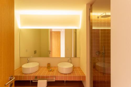 a bathroom with two sinks and a large mirror at Garça Real Flats in Porto