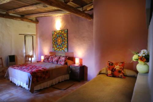 a bedroom with a bed and a couch in a room at Posada La Guadalupe in Tafí del Valle