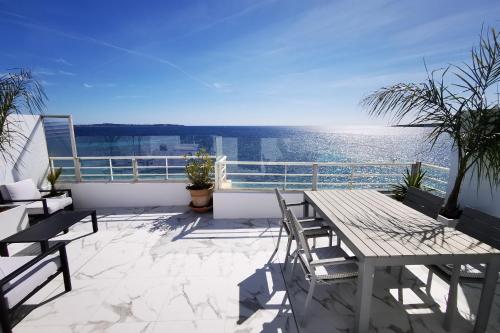 un patio avec une table et des chaises sur un balcon dans l'établissement REF 1769 - Cannes - Sea view penthouse for rent, à Cannes