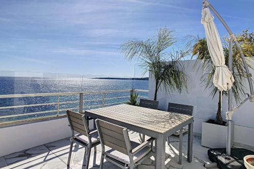 d'une table et de chaises sur un balcon donnant sur l'eau. dans l'établissement REF 1769 - Cannes - Sea view penthouse for rent, à Cannes